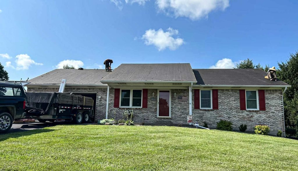Brick ranch style home with a new gray roof and a work truck outside