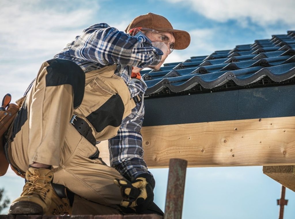 Roofers fitting tiles onto new roof battens