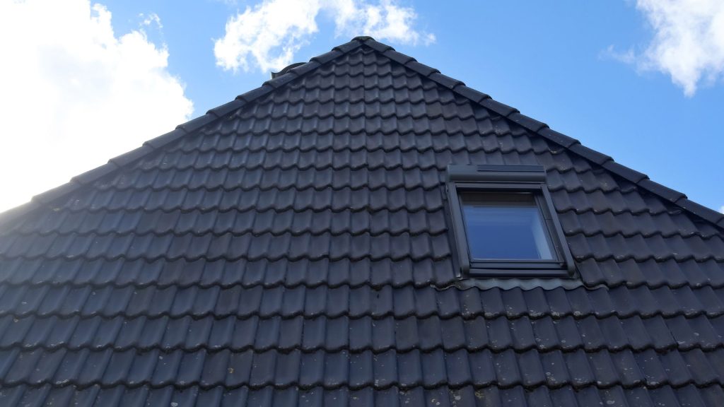 Dark tiled hip roof with a roof window