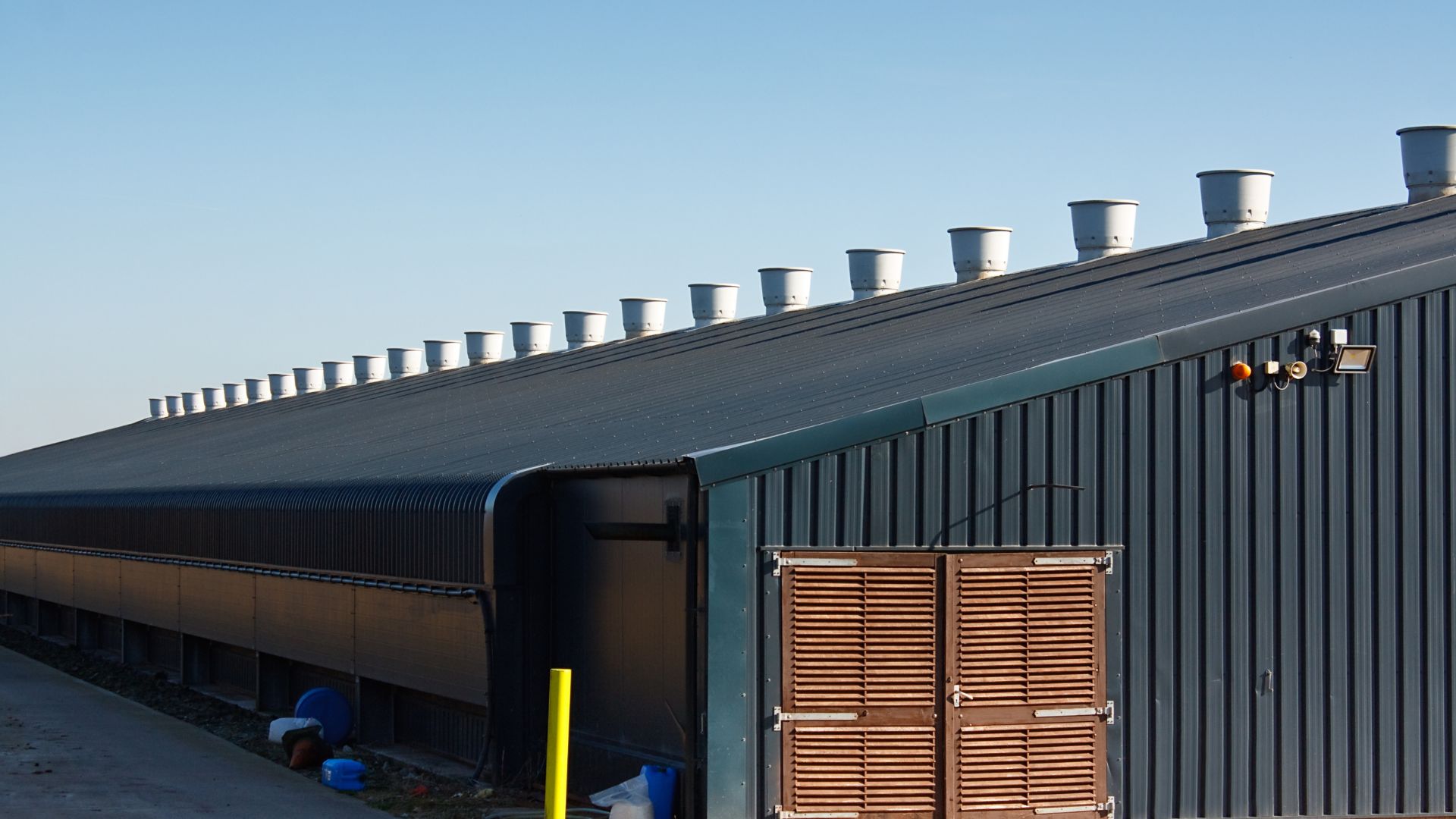 Dark metal industrial building with roof vents