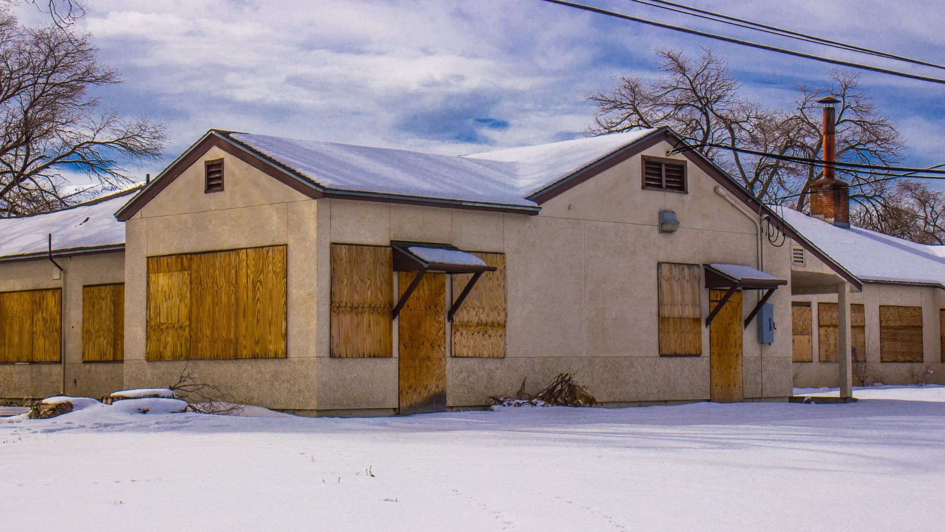 Vacant building with boarded windows after winter weather