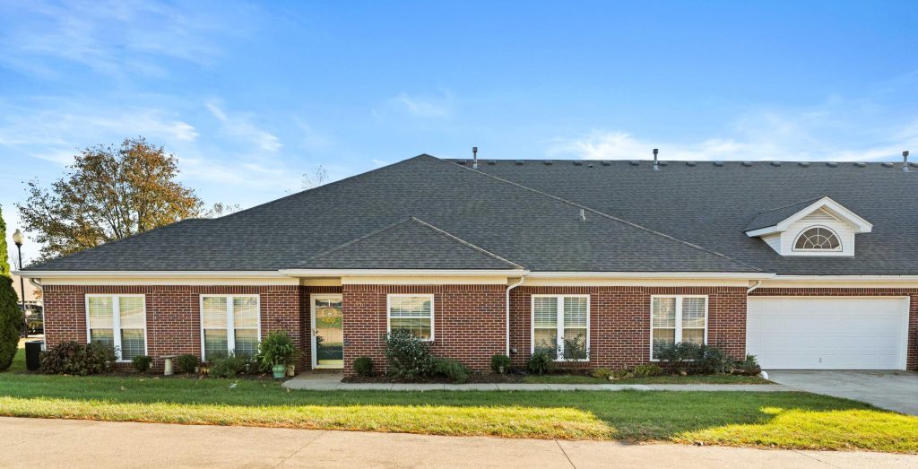 Single story brick home with a gray shingle roof