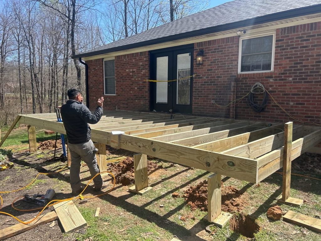 Timber deck frame being built behind a brick home